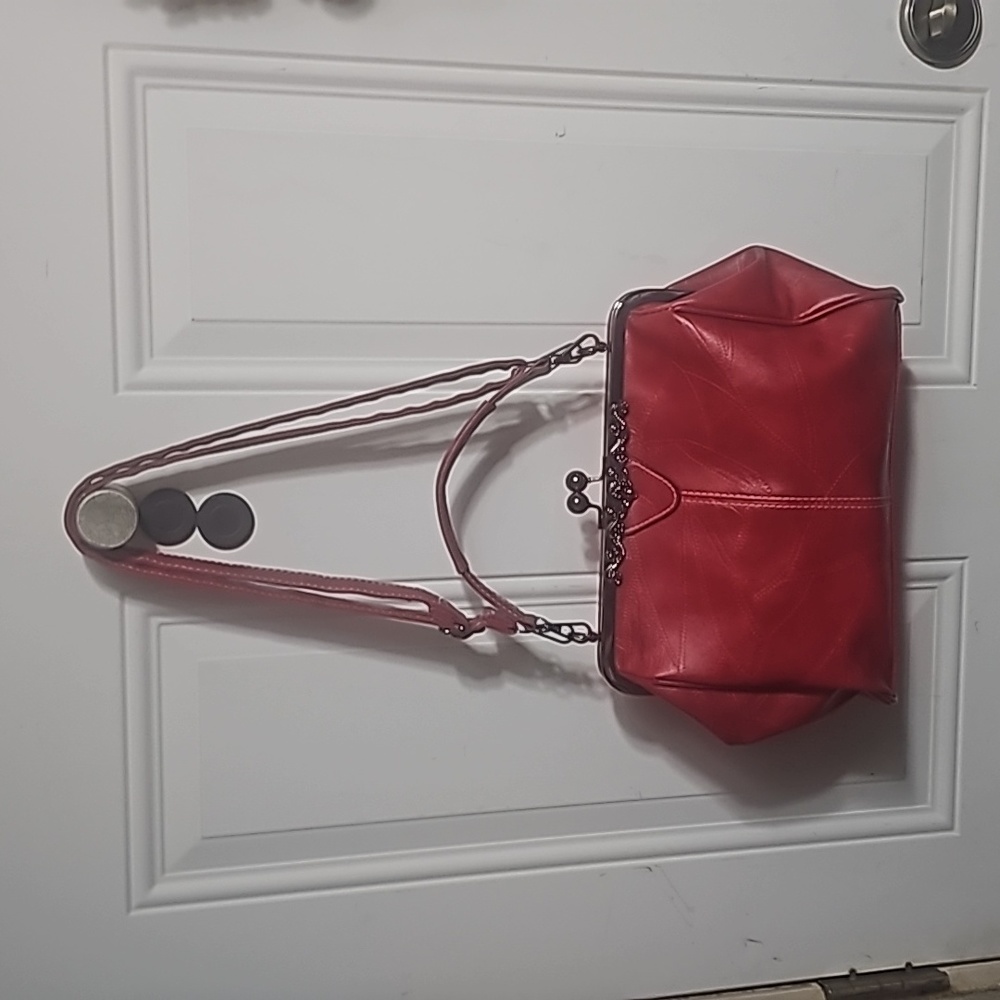 Red leather kisslock crossbody bag with adjustable strap that can also be remove